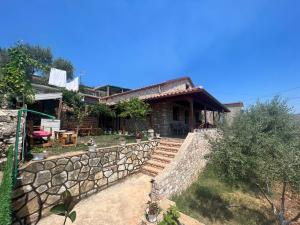 a house with a stone fence and a stone wall at Vokopola Villa in Sarandë