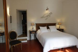 1 dormitorio con 1 cama blanca, 2 mesas y 1 silla en Villa Marie Sete, en Sète