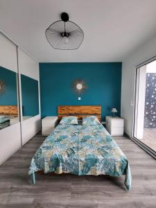 a bedroom with a bed and a blue wall at Appartement cosy au calme in Hasparren