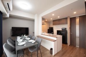 a dining room and kitchen with a table and chairs at THE RISE Osaka Universal Bayside in Osaka