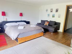 um quarto com uma cama, um sofá e uma cadeira em Bed & Breakfast in car-free Wengen - Hop in Nest BnB em Wengen