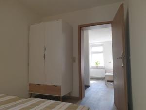 a bedroom with a white cabinet and a window at FeWo Herzenstölen in Sebnitz