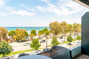 a balcony with a view of a parking lot and the ocean at Yacht Hotel in Vlorë