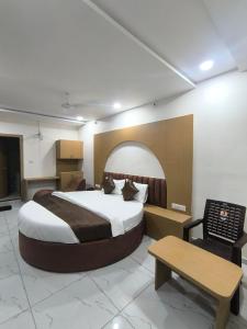 a hotel room with a large bed and a table at Hotel RD in Kadi