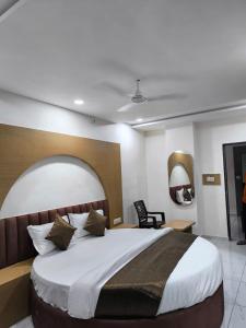 a bedroom with a large bed and two mirrors at Hotel RD in Kadi