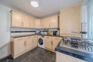 Sleeps 7- Spacious 3 Bed House w Free Parking في ليفربول: مطبخ مع حوض وغسالة أطباق