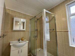 Sleeps 7- Spacious 3 Bed House w Free Parking في ليفربول: حمام مع حوض ودش زجاجي +22 صورة