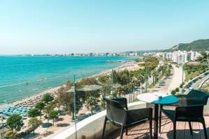 a balcony with chairs and a view of the beach at Yacht Hotel in Vlorë