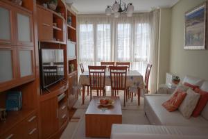 a living room with a couch and a dining room table at Apartamento Aurora cerca de Laredo y Santoña y Piscina Comunitaria in Bádames