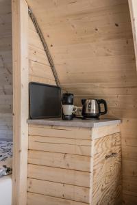 a small counter with a tv on top of a wooden wall at Luxe woodlodge in bosrijke omgeving incl eigen douche en keuken in Bornerbroek
