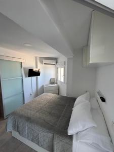 ein Schlafzimmer mit einem Bett in einem weißen Raum in der Unterkunft 1st line La Fossa Luxury Beach Apartment *ADULTS ONLY* in Calpe
