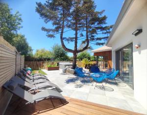 a patio with a bunch of chairs and a tree at Villa et Spa in Pornic