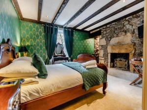 a bedroom with a bed and a stone fireplace at The Tormaukin in Glendevon
