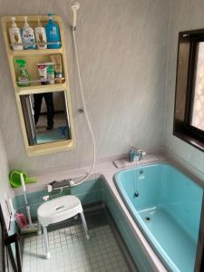 a bathroom with a blue tub and a sink at Monet House モネハウス in Shimo-horado