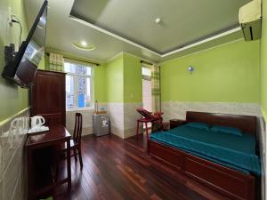 a bedroom with a bed and a desk and a television at Hưng Thịnh 1 in Can Tho