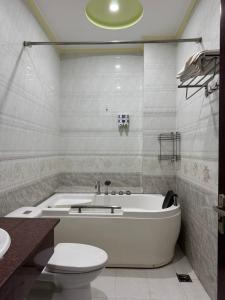 a bathroom with a tub and a toilet and a sink at Hưng Thịnh 1 in Can Tho +10 photos
