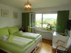una camera da letto con un letto, una finestra e una sedia di B&B Pappelweg - 2 a Muttenz