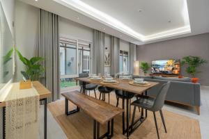 a dining room with a table and a couch at Layali Properties - Vibrant Boho 3BR Apt - Convention and Exhibition Center in Riyadh