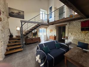 un soggiorno con un divano blu e una scala di Marais Inn, maison typique avec piscine et jardin arboré, 10 kms Niort a Sansais