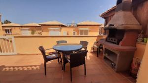 eine Terrasse mit einem Tisch, Stühlen und einem Herd in der Unterkunft SeaHaus Fuerte in Corralejo