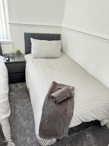 ein Schlafzimmer mit einem Bett und einem Handtuch darauf in der Unterkunft Modern House In Acocks Green - Free Parking & Wi-Fi in Birmingham