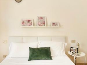 a bedroom with a white bed with a green pillow at Holihome Room Eight in Tortoreto Lido +12 photos