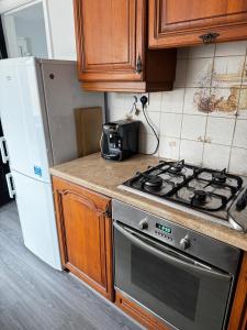 eine Küche mit Herd und Kühlschrank in der Unterkunft Modern House In Acocks Green - Free Parking & Wi-Fi in Birmingham + 21 Fotos