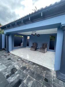 a patio with two chairs under a blue building at Goldman Florida Guesthouse in Roodepoort +21 photos