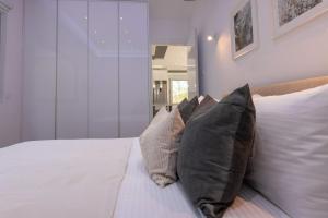a bedroom with a white bed with four pillows at Palaiomylos Forest Residence 