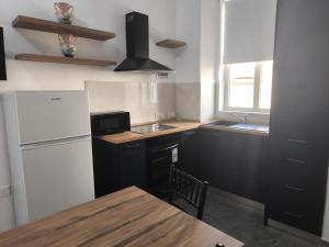 a kitchen with a white refrigerator and a sink at Violet Apartments in Msida