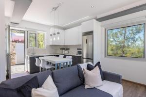 a living room with a blue couch and a kitchen at Palaiomylos Forest Residence 