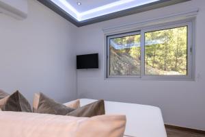 a bedroom with a bed and a window at Palaiomylos Forest Residence 