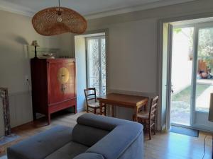 a living room with a blue couch and a table at Les Bruneilles in Dracy-le-Fort