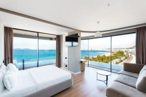 a bedroom with a large white bed and a couch at Yacht Hotel in Vlorë