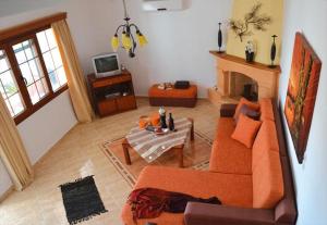 un soggiorno con un divano arancione e un camino di Eden Villa ad Alinda