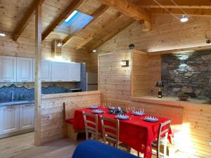 a dining room with a red table in a kitchen at Bella Italia chalet in Massino Visconti
