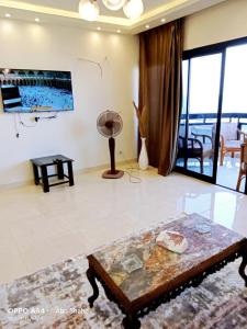 a living room with a table and a large window at Gleem Bay ultra lux Apartment in Alexandria +6 photos