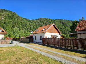 a house with a fence in front of a mountain at Apartmány Petronela Hrabušická Píla in Hrabušice