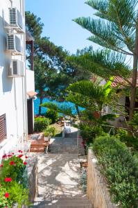 een pad naar een huis met uitzicht op de oceaan bij Apartments & Rooms Bianca in Mali Lošinj
