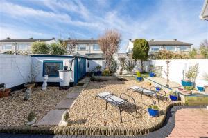 a backyard with two chairs and a table and a fence at 7 Sonesta Malahide in Balnacart