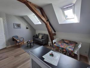 a living room with a couch and a table at Gîte 4 pers, Jacuzzi privatif & Piscine & Lit cabane in Saint-Georges-sur-Cher
