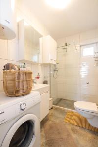a white bathroom with a washing machine and a toilet at Apartmani Simona Tribunj in Tribunj