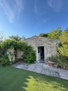 un edificio in pietra con una porta e un cortile di Marais Inn, maison typique avec piscine et jardin arboré, 10 kms Niort a Sansais