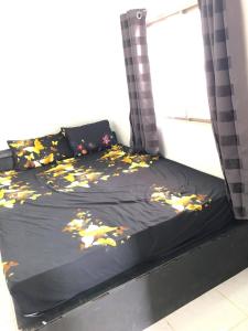 ein Bett mit einer schwarzen Bettdecke mit Schmetterlingen darauf in der Unterkunft Ohana Semeistvo Beach house in Sampong + 6 Fotos