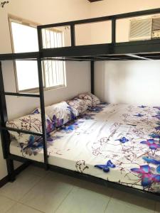 ein Schlafzimmer mit einem Etagenbett mit einer weißen Tagesdecke in der Unterkunft Ohana Semeistvo Beach house in Sampong