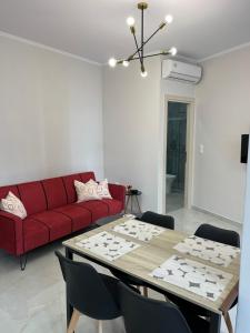 a living room with a red couch and a table at Home-1611 in Paramythia +6 photos