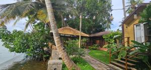 Munroe IslandGreenChromide Homestays的水边有棕榈树的房子