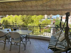 a patio with a table and chairs and a balcony at Saronida Beachwalk Stay in Saronida