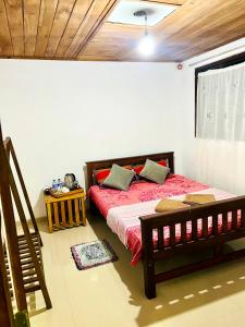 a bedroom with a bed with red sheets and a window at DK Paddy Field Villa in Unawatuna in Unawatuna