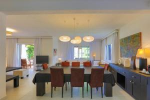 a dining room and living room with a table and chairs at VILLA avec Rooftop Bahia Smir bord de mer in Fnidek